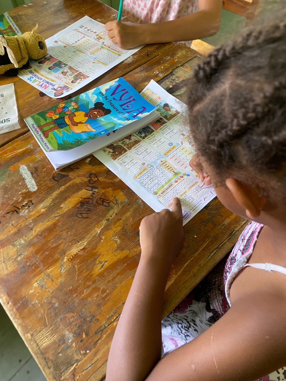 Children engaging with Nyla the TVET Explorer books and worksheets