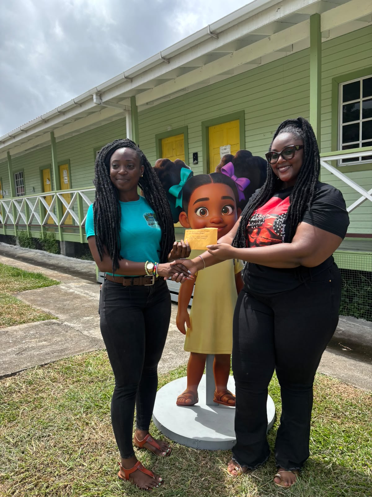 Pearlette Primus Hannaway presenting a donation to a Reading Adventure Camp organiser beside the life-size Nyla cutout